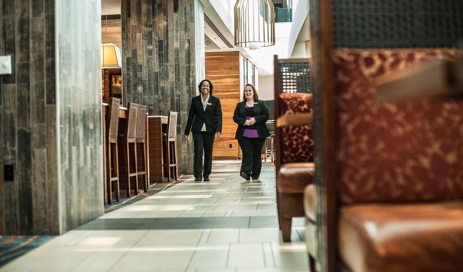 Two female members of staff walking through a White Lodging managed hotel.