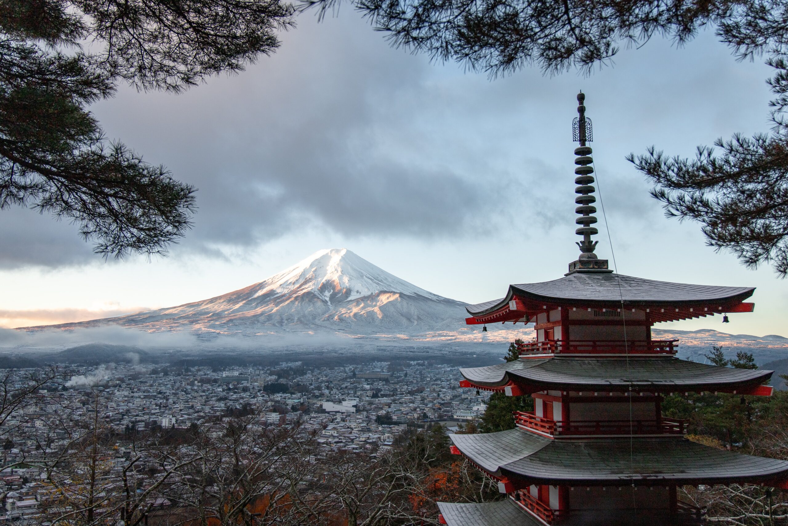 A picture of a temple with Mount Fuji in the background.