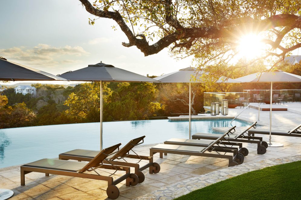 view of mountains by a pool with lounge chairs